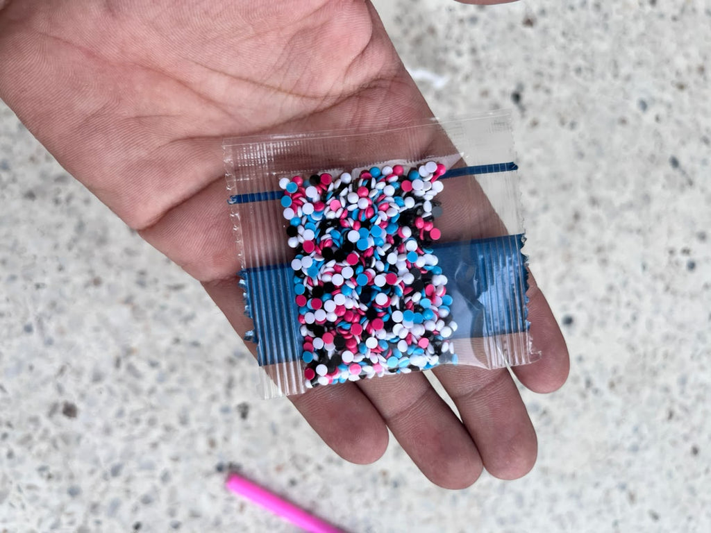 Small red diamond painting wax square resting on an open palm